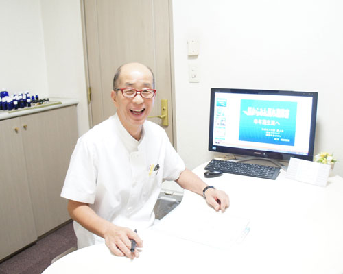 気になる症状へのボタン(診察室にいる笑顔の横倉院長)